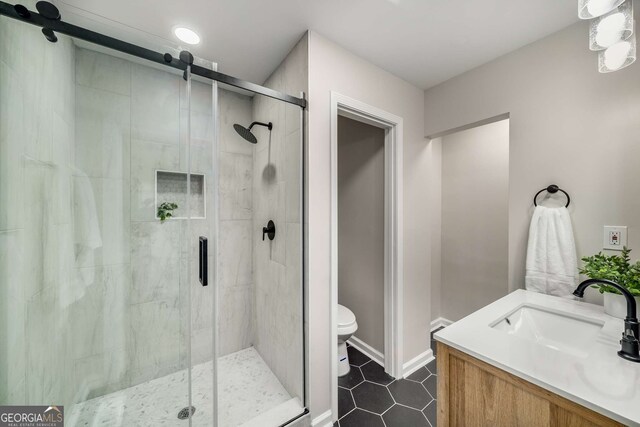 full bathroom with tile patterned flooring, baseboards, toilet, a stall shower, and vanity