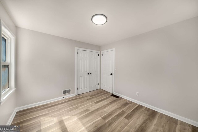 empty room with visible vents, baseboards, and light wood-style floors