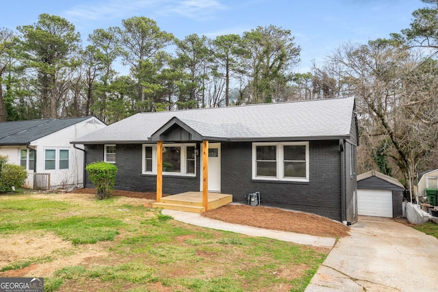 ranch-style house with brick siding, concrete driveway, a front yard, a garage, and an outbuilding