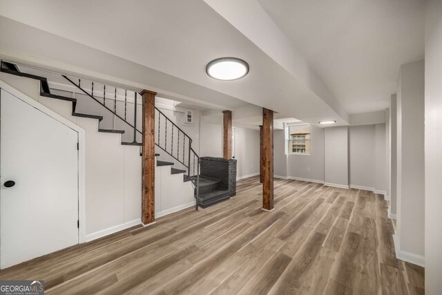 basement with stairway, wood finished floors, and baseboards