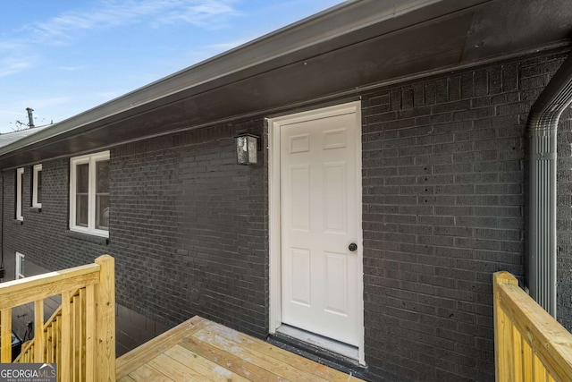 entrance to property featuring brick siding