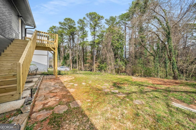 view of yard with a wooden deck and stairs