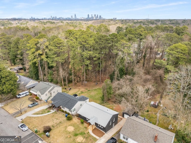 bird's eye view with a wooded view