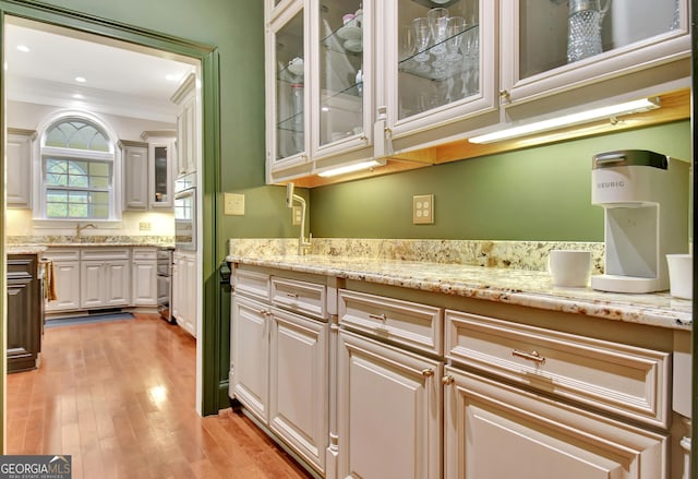 1575 Oak Mountain Rd, Shiloh, GA 31826 - kitchen featuring a sink, light wood-style flooring, light stone countertops, ornamental molding, and oven