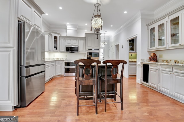 1575 Oak Mountain Rd, Shiloh, GA 31826 - kitchen featuring appliances with stainless steel finishes, a kitchen breakfast bar, a kitchen island, and light wood-type flooring