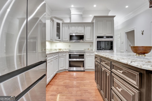 1575 Oak Mountain Rd, Shiloh, GA 31826 - kitchen featuring crown molding, glass insert cabinets, light wood-style floors, light stone counters, and appliances with stainless steel finishes