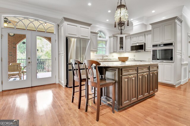 1575 Oak Mountain Rd, Shiloh, GA 31826 - kitchen featuring stainless steel appliances, a center island, light wood-style floors, a breakfast bar, and ornamental molding
