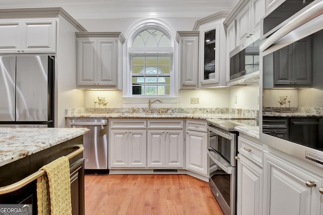 1575 Oak Mountain Rd, Shiloh, GA 31826 - kitchen featuring appliances with stainless steel finishes, light wood-type flooring, white cabinets, and ornamental molding