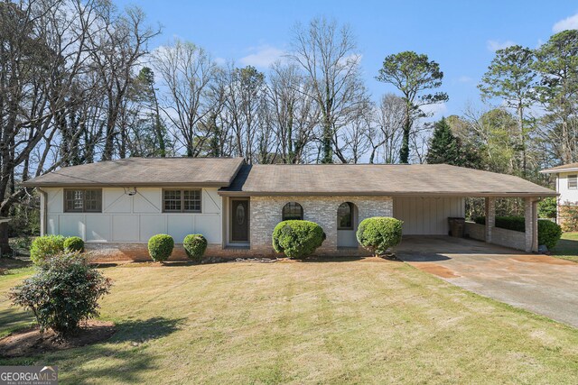 view of front facade with brick siding, a lawn, board and batten siding, and concrete driveway