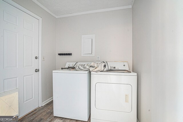 laundry area with washing machine and clothes dryer, wood finished floors, a textured ceiling, ornamental molding, and laundry area