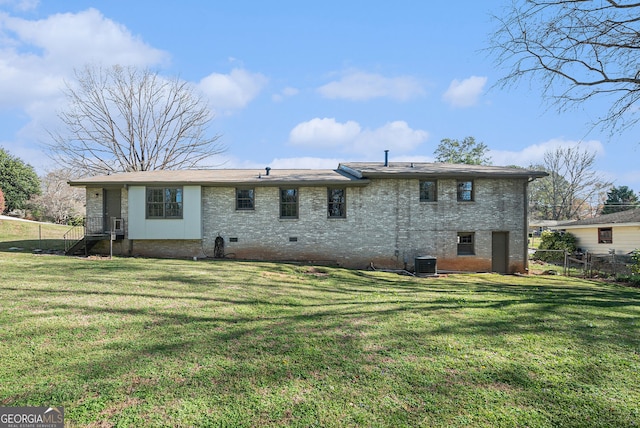 rear view of property with cooling unit, crawl space, a yard, and fence