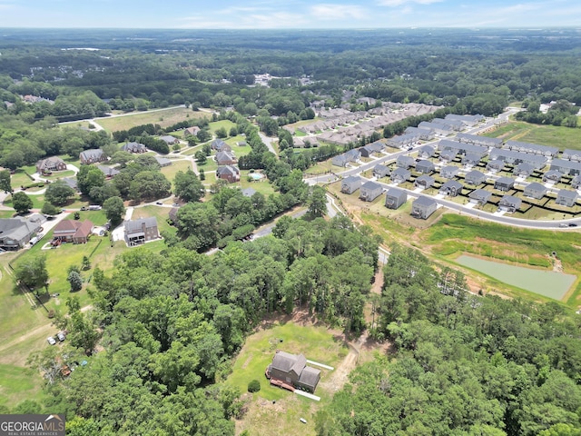 birds eye view of property with a residential view, a wooded view, and a water view