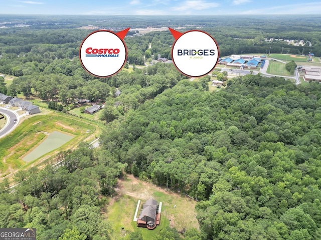 birds eye view of property with a forest view and a water view