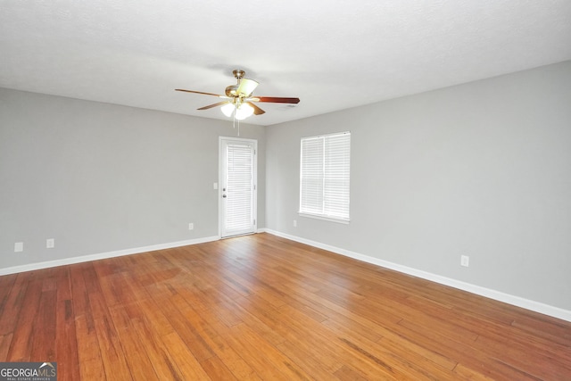 empty room with light wood-style flooring, baseboards, and ceiling fan