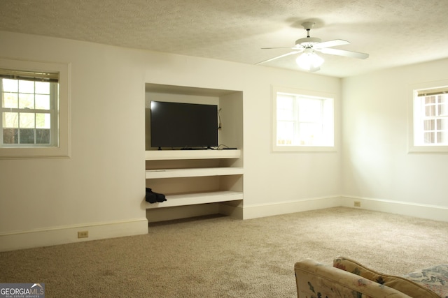 3348 Summit Turf Ln, Snellville, GA 30078 - unfurnished living room featuring carpet, a textured ceiling, a ceiling fan, and baseboards