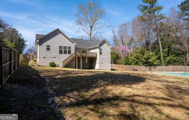 rear view of house featuring a lawn, stairs, and a fenced backyard
