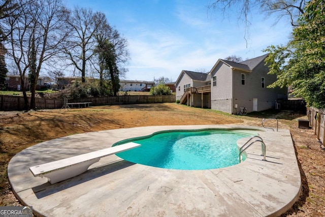 view of swimming pool featuring a patio, a fenced backyard, a residential view, a diving board, and a fenced in pool