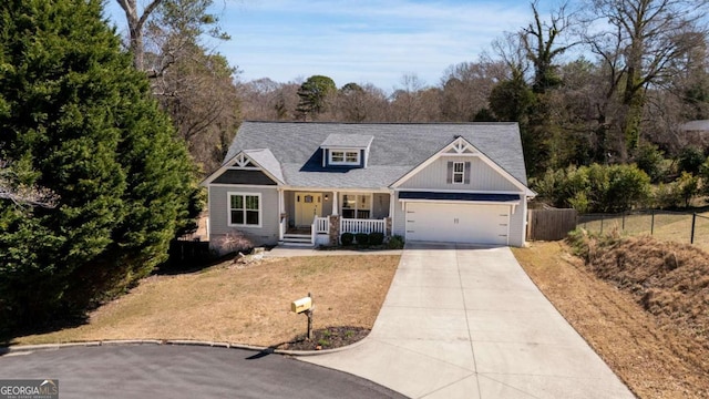 view of front of house with concrete driveway, fence, and covered porch