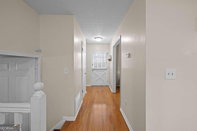 1417 Hickory Dr SW, Lilburn, GA 30047 - hall featuring light wood-style flooring and an upstairs landing