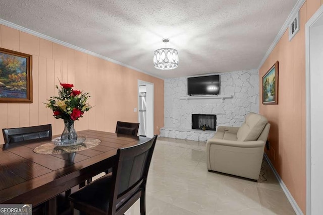 1417 Hickory Dr SW, Lilburn, GA 30047 - dining area with a textured ceiling, crown molding, a stone fireplace, and a chandelier
