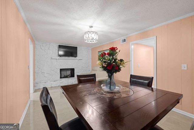 1417 Hickory Dr SW, Lilburn, GA 30047 - dining room with a textured ceiling, a fireplace, a chandelier, and crown molding