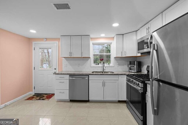 1417 Hickory Dr SW, Lilburn, GA 30047 - kitchen featuring stainless steel appliances, decorative backsplash, light stone counters, and recessed lighting