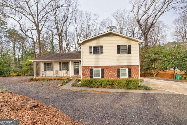 1417 Hickory Dr SW, Lilburn, GA 30047 - split level home with a porch, brick siding, and driveway