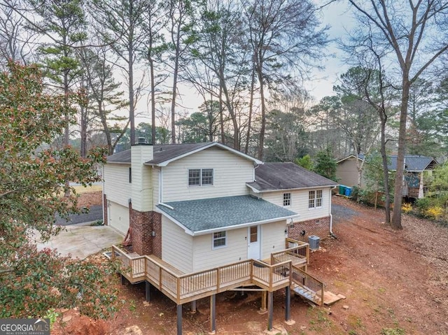 1417 Hickory Dr SW, Lilburn, GA 30047 - rear view of house with a wooden deck, a shingled roof, a chimney, stairs, and concrete driveway