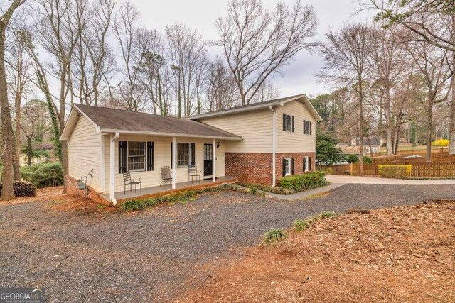 1417 Hickory Dr SW, Lilburn, GA 30047 - tri-level home with a porch, driveway, and brick siding