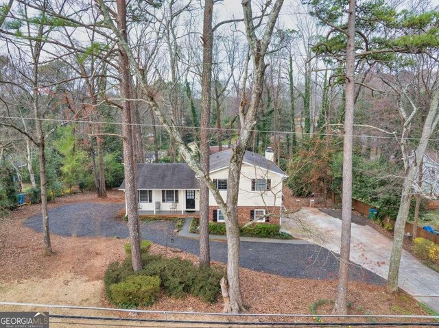 1417 Hickory Dr SW, Lilburn, GA 30047 - view of front facade featuring driveway, a chimney, and brick siding