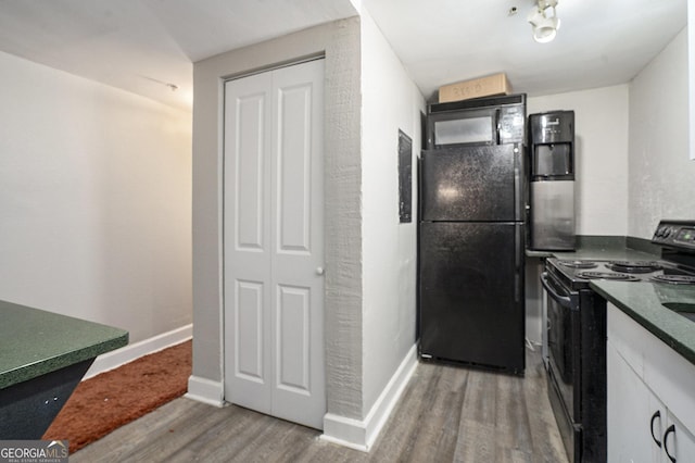 385 Ralph Mcgill Blvd NE Unit D, Atlanta, GA 30312 - kitchen with black appliances, wood finished floors, dark countertops, white cabinets, and baseboards