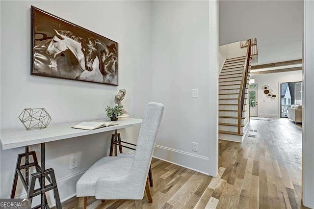 office area featuring baseboards, built in study area, and wood finished floors