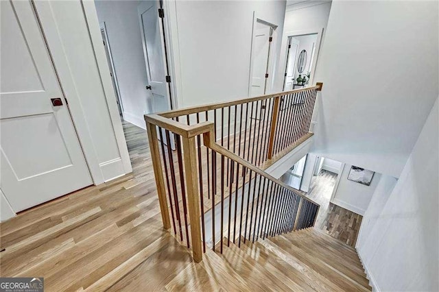 staircase with baseboards and wood finished floors