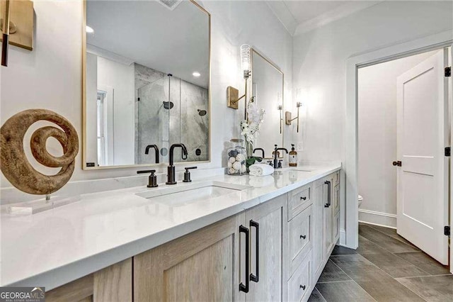full bathroom with a stall shower, double vanity, ornamental molding, and a sink
