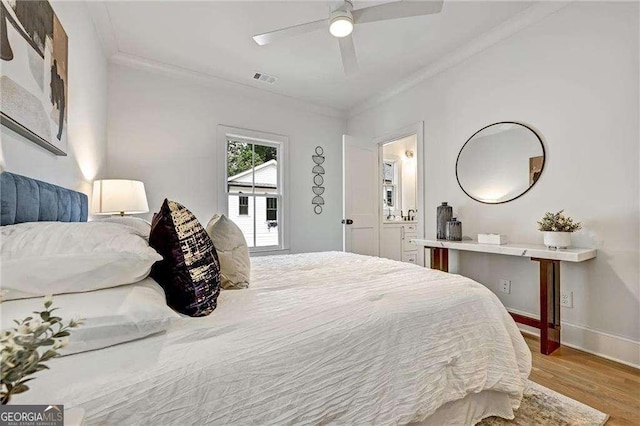 bedroom with crown molding, a ceiling fan, wood finished floors, baseboards, and visible vents