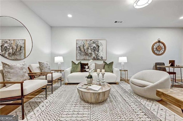 living room featuring baseboards, visible vents, recessed lighting, and light wood-type flooring