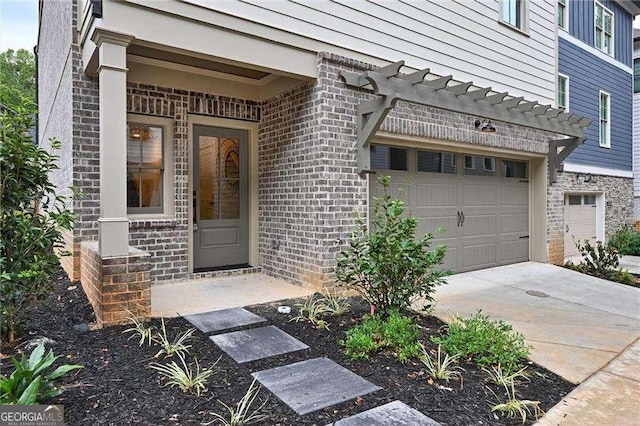 property entrance with brick siding, a garage, and concrete driveway
