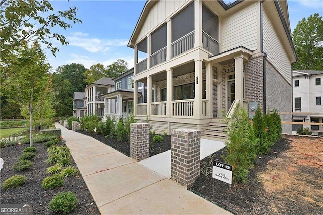 view of home's exterior featuring brick siding, a porch, and board and batten siding