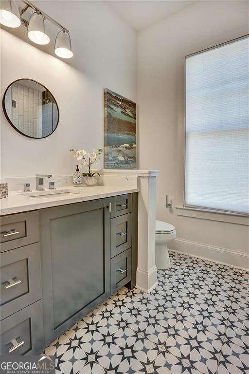 bathroom featuring toilet, vanity, tile patterned floors, and baseboards