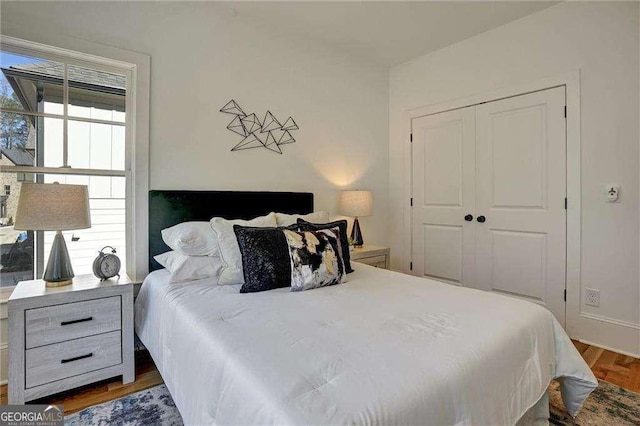 bedroom featuring a closet, wood finished floors, and multiple windows