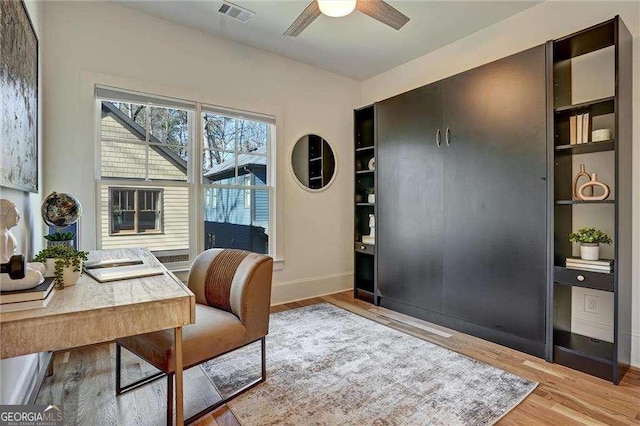 home office featuring baseboards, visible vents, wood finished floors, and ceiling fan