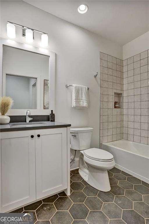 full bathroom featuring toilet, vanity, shower / bath combination, and tile patterned floors