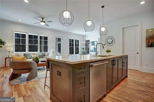 kitchen featuring dishwasher, a ceiling fan, a sink, light wood-style floors, and open floor plan