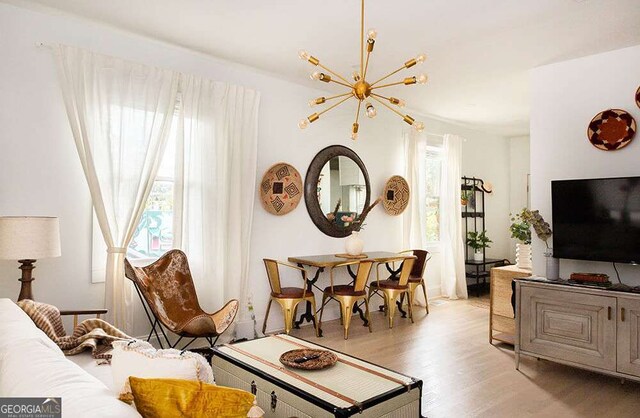 living area with light wood-style flooring and a chandelier