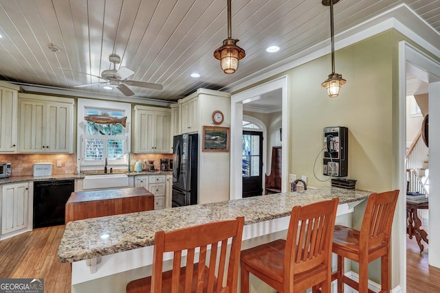 1108 E Mission Ln SE, Darien, GA 31305 - kitchen with black appliances, a sink, light wood-style flooring, a ceiling fan, and a kitchen breakfast bar