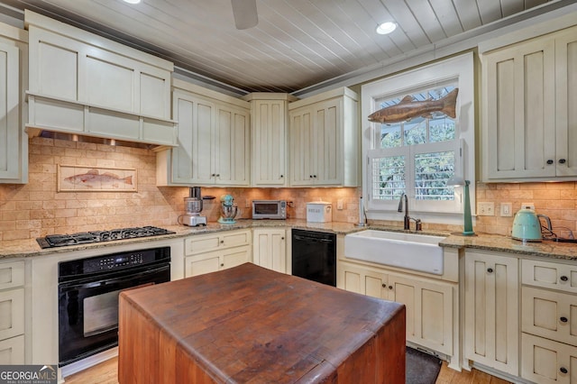 1108 E Mission Ln SE, Darien, GA 31305 - kitchen with black appliances, a sink, decorative backsplash, cream cabinets, and recessed lighting