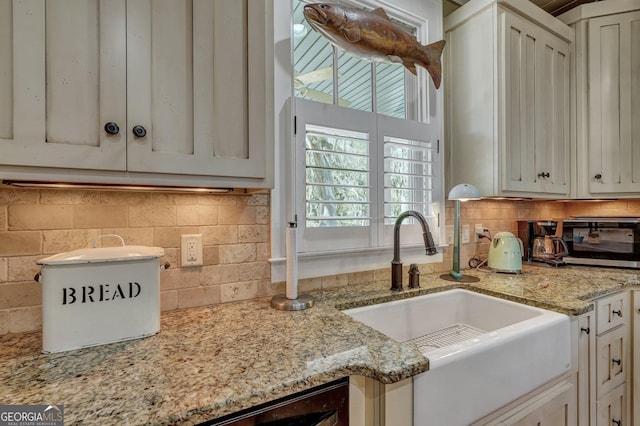 1108 E Mission Ln SE, Darien, GA 31305 - kitchen with a sink, backsplash, light stone counters, and white cabinetry