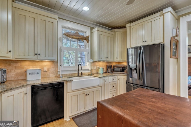 1108 E Mission Ln SE, Darien, GA 31305 - kitchen with black dishwasher, stainless steel fridge, a sink, cream cabinetry, and wood ceiling