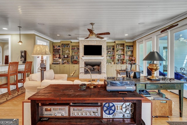 living area with ceiling fan, a fireplace, ornamental molding, recessed lighting, and wood finished floors