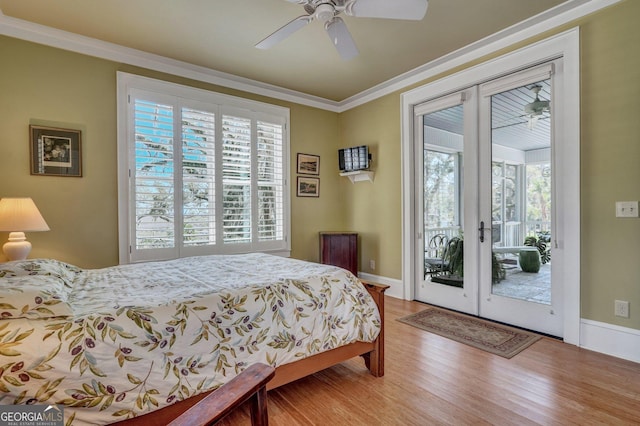 bedroom featuring french doors, access to exterior, wood finished floors, and multiple windows